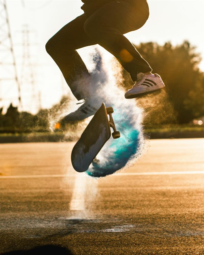 Bilde av to ben på et skateboard på en fotballbane